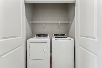 Two white washing machines in a laundry room.